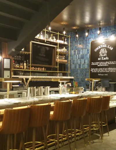 The bar area of a restaurant with a blue tiled wall.