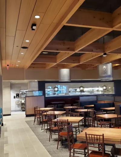 The interior of a restaurant with blue booths and wooden ceilings.