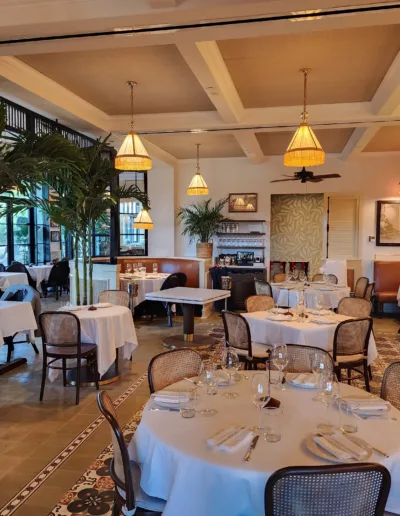 The dining room of a restaurant with tables and chairs.