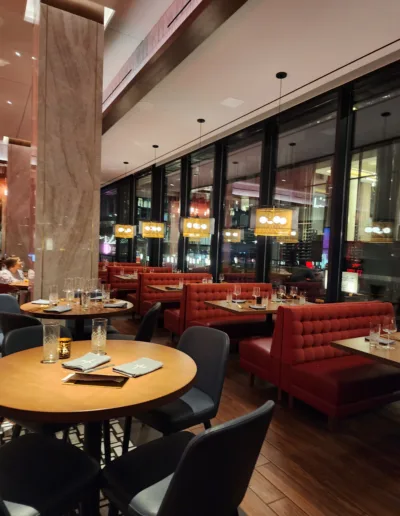 The interior of a restaurant with red booths and tables.