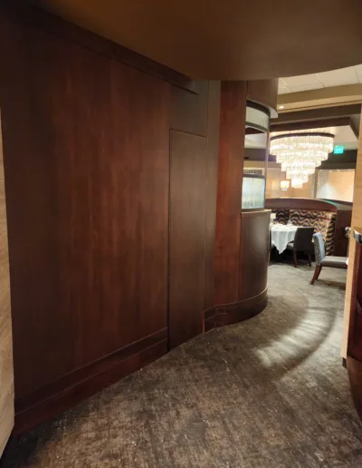 A dining room with wooden walls and a chandelier.