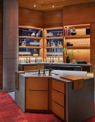 A modern kitchen with wooden cabinets and red carpet.